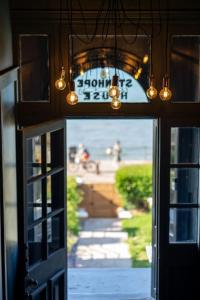 une porte ouverte avec vue sur l'océan et un panneau dans l'établissement Beachfront Bolthole with Luxury, Style and Spectacular Sea Views, à Herne Bay