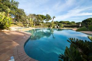 een groot zwembad met blauw water in een tuin bij Apartamento Luna - Golf View By Dalma Portuguesa in Branqueira