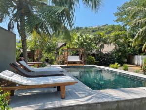 a swimming pool with two lounge chairs and a table at maison vanilianadia in Nosy Be