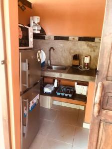 a small kitchen with a sink and a refrigerator at maison vanilianadia in Nosy Be