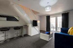 a living room with a staircase and a blue couch at Durham Gate View in Spennymoor