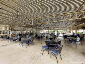 a large room with tables and chairs and a piano at CAMPO BELO RESORT in Presidente Prudente