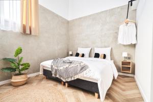 1 dormitorio con 1 cama y una maceta en Na Fursie Apartments & Rooms, en Nowy Targ