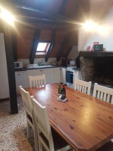 een keuken met een houten tafel en witte stoelen bij Alexandras.gite in Boutx