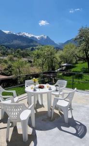 a white table and chairs on a patio with mountains at Mountain Home Bran in Bran