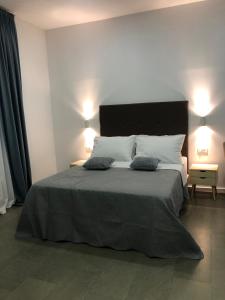 a bedroom with a large bed with two pillows on it at Elvis Rooms Airport in Velika Gorica