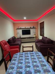 sala de estar con sofás y TV con iluminación roja en Casa de praia - Arraial do Cabo, en Arraial do Cabo