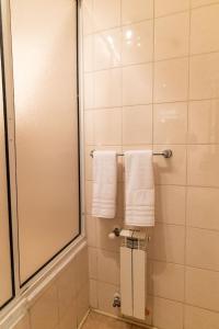 a bathroom with white towels and a shower at Darwin Hotel in Puerto Natales