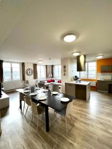 a living room with a table and chairs and a kitchen at Grand apt lumineux avec extérieur centre bourg 600 m plage proche Omaha Beach et pointe du Hoc in Vierville-sur-Mer