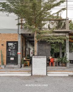 a building with a table and chairs in front of it at YOJI House and Cafe in Ban Wiang