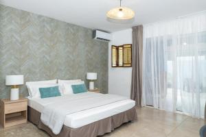 a bedroom with a large bed and a window at Charme Alizea Skyline wifi-terrasse in Rémire-Camp