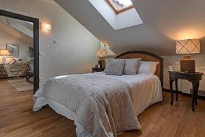 um quarto com uma cama grande e uma clarabóia em Hospedium Hotel La Farm em La Granja de San Ildefonso