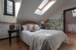 a bedroom with a bed with a white comforter at Hospedium Hotel La Farm in La Granja de San Ildefonso