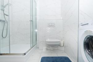 a white bathroom with a toilet and a shower at WaterFront City Apartments by UrbanRent in Budapest