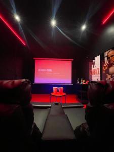 um quarto com um grande ecrã num teatro em Suite cinéma et jacuzzi privé em Melun