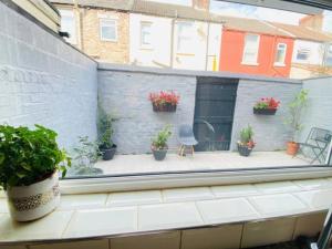 an open window with potted plants on a patio at Entire 4 bedroom House - EV POINT & FREE PARKING in Liverpool