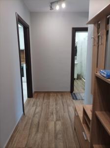 baño con paredes blancas, suelo de madera y espejo en One Bedroom Apartment 37- Trakia 54 А en Plovdiv