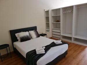 - une chambre avec un lit doté de draps et d'oreillers blancs dans l'établissement Tomás Flat, à Porto