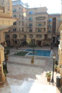 een groot gebouw met een zwembad ervoor bij Jasmine Pyramids Hotel in Caïro
