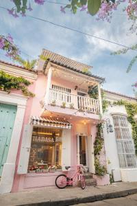 una bicicleta rosa estacionada frente a un edificio en CASA HADASA en Cartagena de Indias