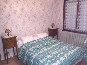 a bedroom with a bed with a green and white blanket at Appartement Mont-Dore, 2 pièces, 4 personnes - FR-1-415-31 in Le Mont-Dore