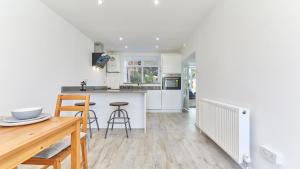 a kitchen with white cabinets and a table and chairs at The Pink House in Durham