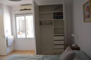1 dormitorio con cama y armario con ventana en Hermoso departamento en G. Cruz en Godoy Cruz