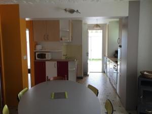 une cuisine avec une table et une cuisine avec une table et des chaises dans l'établissement Maison de Plain-Pied à 700m de la Plage avec Jardin Privé, BBQ, et Parking – 6 Couchages - FR-1-246A-319, à Dolus-d'Oléron