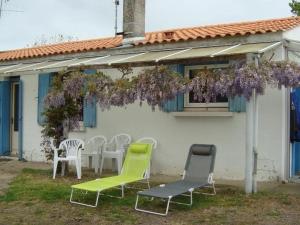 un groupe de chaises et de tables devant une maison dans l'établissement Maison de Plain-Pied à 700m de la Plage avec Jardin Privé, BBQ, et Parking – 6 Couchages - FR-1-246A-319, à Dolus-d'Oléron 9 autres photos