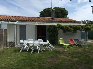- une table et des chaises dans la cour d'une maison dans l'établissement Maison de Plain-Pied à 700m de la Plage avec Jardin Privé, BBQ, et Parking – 6 Couchages - FR-1-246A-319, à Dolus-d'Oléron