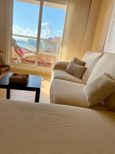 a living room with a couch and a large window at Precioso apartamento en primera línea de playa in San Blas