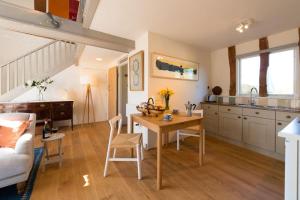 uma cozinha e sala de estar com mesa e cadeiras em Deepwell Granary is a lovely thatched barn with attached meadow woodland em Buxhall