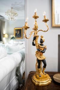 una lámpara de oro en una mesa junto a una cama en Giò&Giò Venice B&B, en Venecia