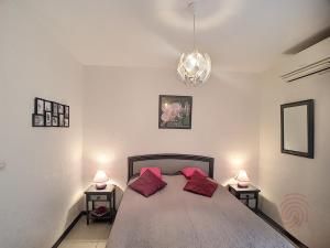 ラマルー・レ・バンにあるAppartement Lamalou-les-Bains, 2 pièces, 2 personnes - FR-1-451-22のベッドルーム1室(大型ベッド1台、赤い枕2つ付)