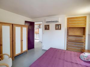 ラマルー・レ・バンにあるAppartement Lamalou-les-Bains, 2 pièces, 2 personnes - FR-1-451-4のベッドルーム(紫色のベッド1台、木製クローゼット付)