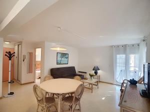 uma sala de estar com uma mesa e um sofá em Appartement Lamalou-les-Bains, 2 pièces, 2 personnes - FR-1-451-23 em Lamalou-les-Bains