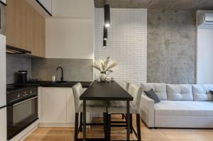 a kitchen and living room with a table and a couch at 3131Designer apartments in the residential complex "Yaroslaviv Grad" in Kyiv