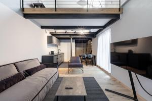 a living room with a couch and a table at Stay COOPER l CITY LOFT in Bolzano