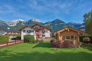 a house in a yard with mountains in the background at Landhaus Maltermoos in Schönau am Königssee