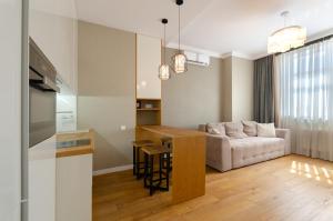 a kitchen and living room with a couch and a table at 1088 Cozy apartment in residential complex ''French Quarter1 in Kyiv