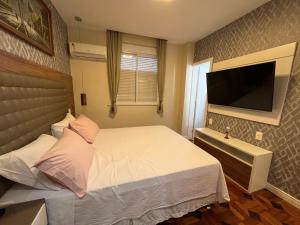 - une chambre avec un lit blanc et une télévision à écran plat dans l'établissement Copa Paradiso, à Rio de Janeiro