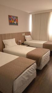 um quarto de hotel com duas camas num quarto em Hotel 7 Itajaí em Itajaí