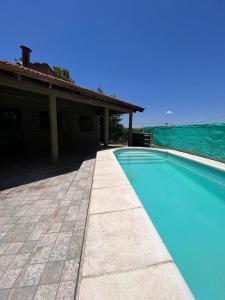 una piscina frente a una casa en El sueño de mama en Santa Rosa de Calamuchita