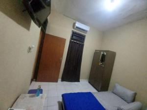 - une petite chambre avec un lit bleu et une porte dans l'établissement EKSOTIS ROOMS SYARIAH, à Seturan