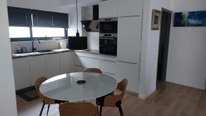 une cuisine blanche avec une table et des chaises dans l'établissement Charming Apartment in Chalandri, à Athènes