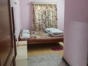 a bed in a room with a curtain and a window at Jwala Niketan Guesthouse Private rooms in Jaipur