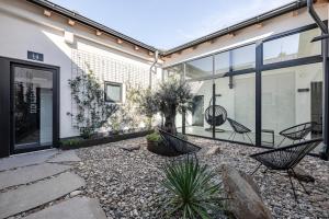 a courtyard with chairs and plants in a house at Stay COOPER l CITY LOFT in Bolzano