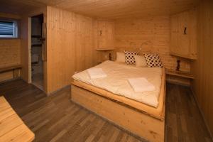 a bedroom with a bed in a wooden cabin at Hotel Santana in Roveredo