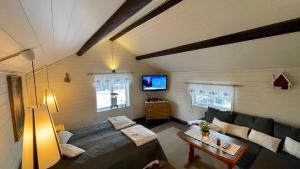 ein Wohnzimmer mit einem Sofa und einem TV in der Unterkunft Prinsgården B&B rum stugor in Mora