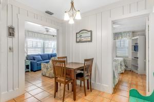 a dining room and living room with a table and chairs at The Seashell Cottage in Anna Maria